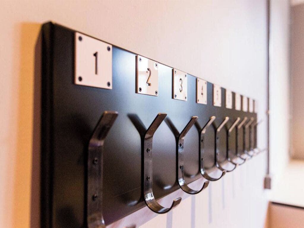 A wall-mounted coat rack with numbered hooks, likely in a hotel or similar accommodation.