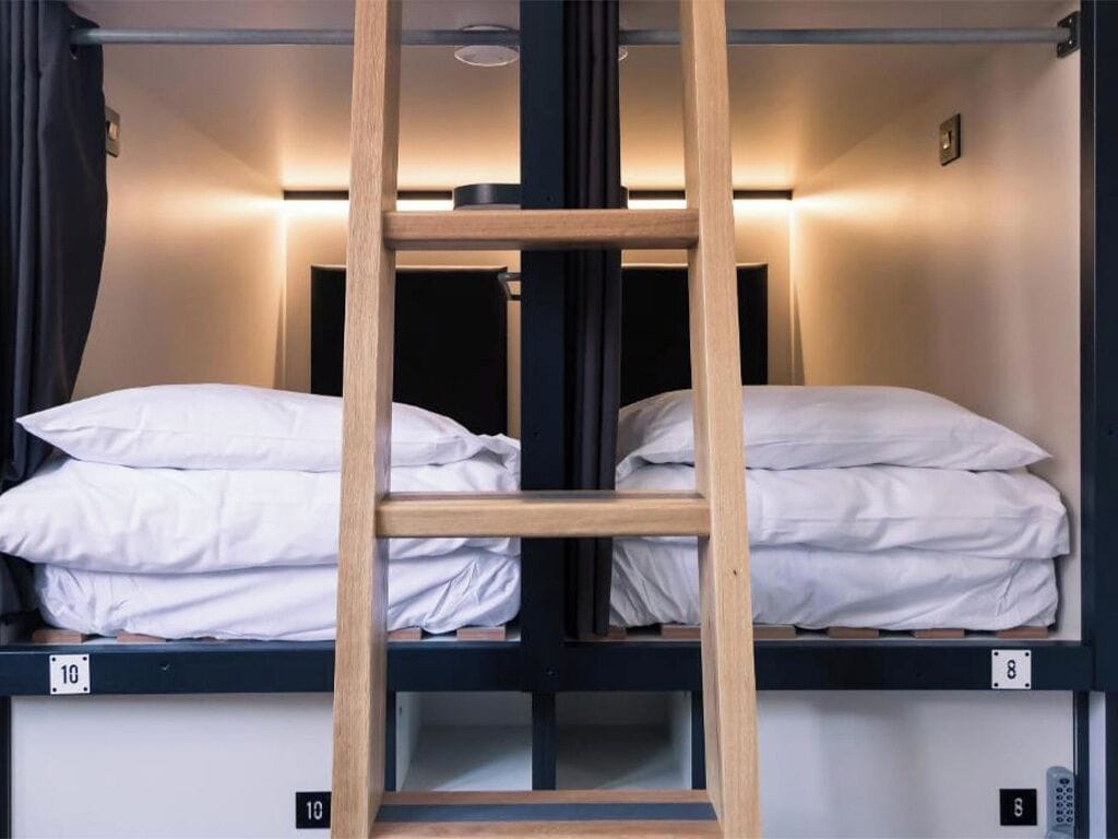 A bunk bed with wooden frames and white bedding, labeled with numbers 8 and 10.