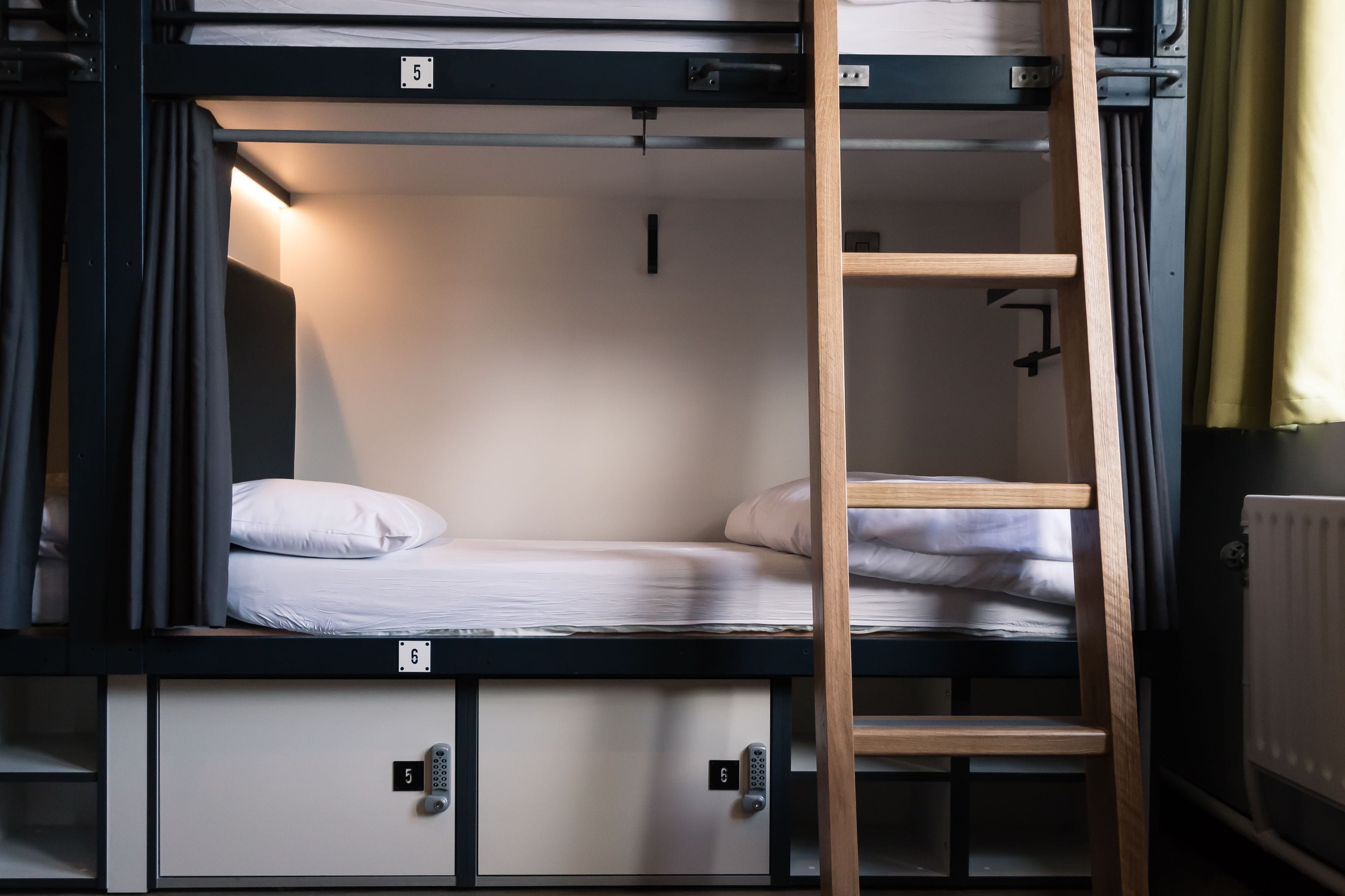 A bunk bed with a ladder, a small desk, and a storage cabinet.