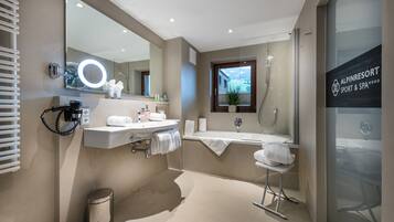 A modern bathroom with a large mirror, a vanity with a sink, a bathtub, and a shower.