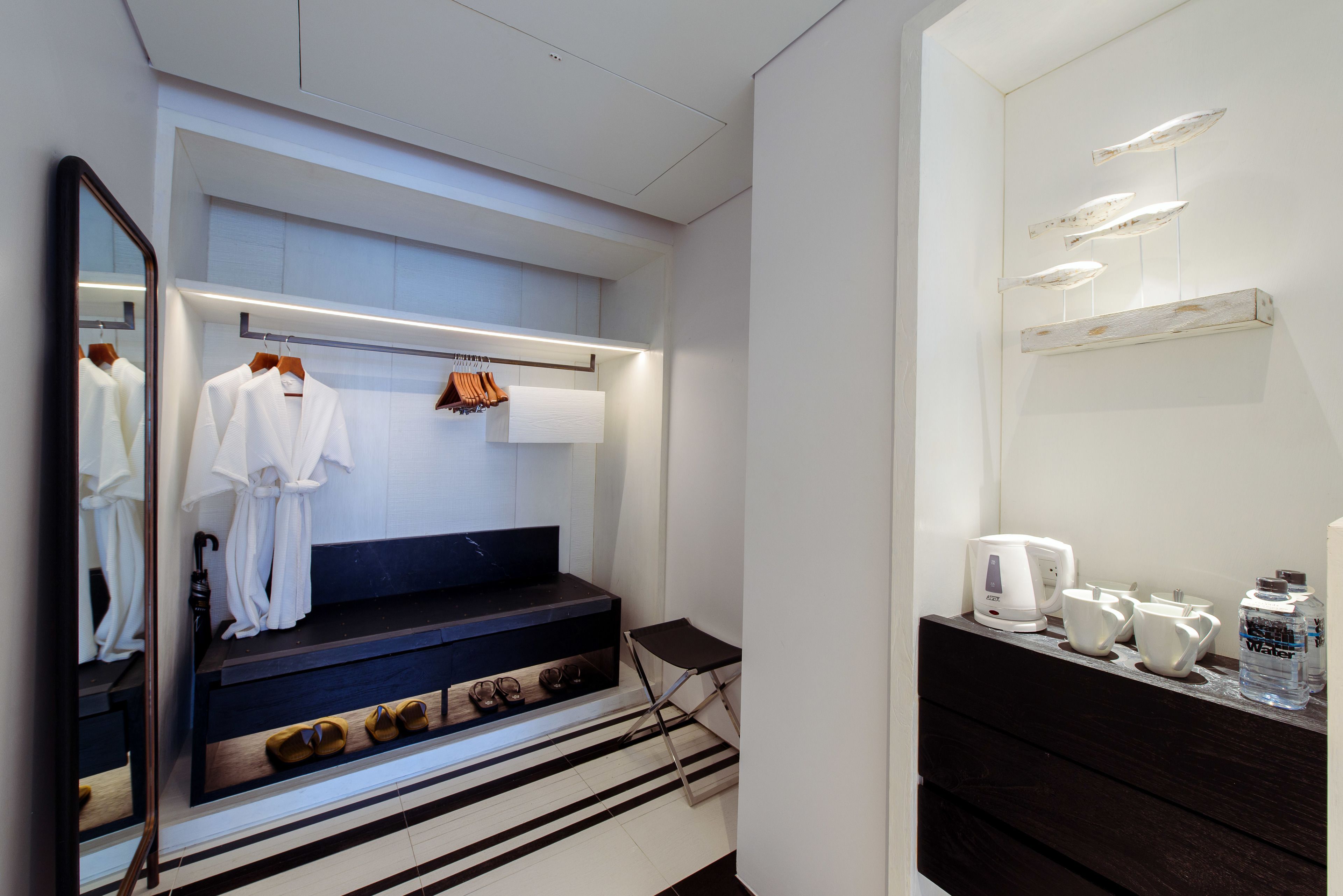 A modern bathroom with a vanity, mirror, and towel rack.