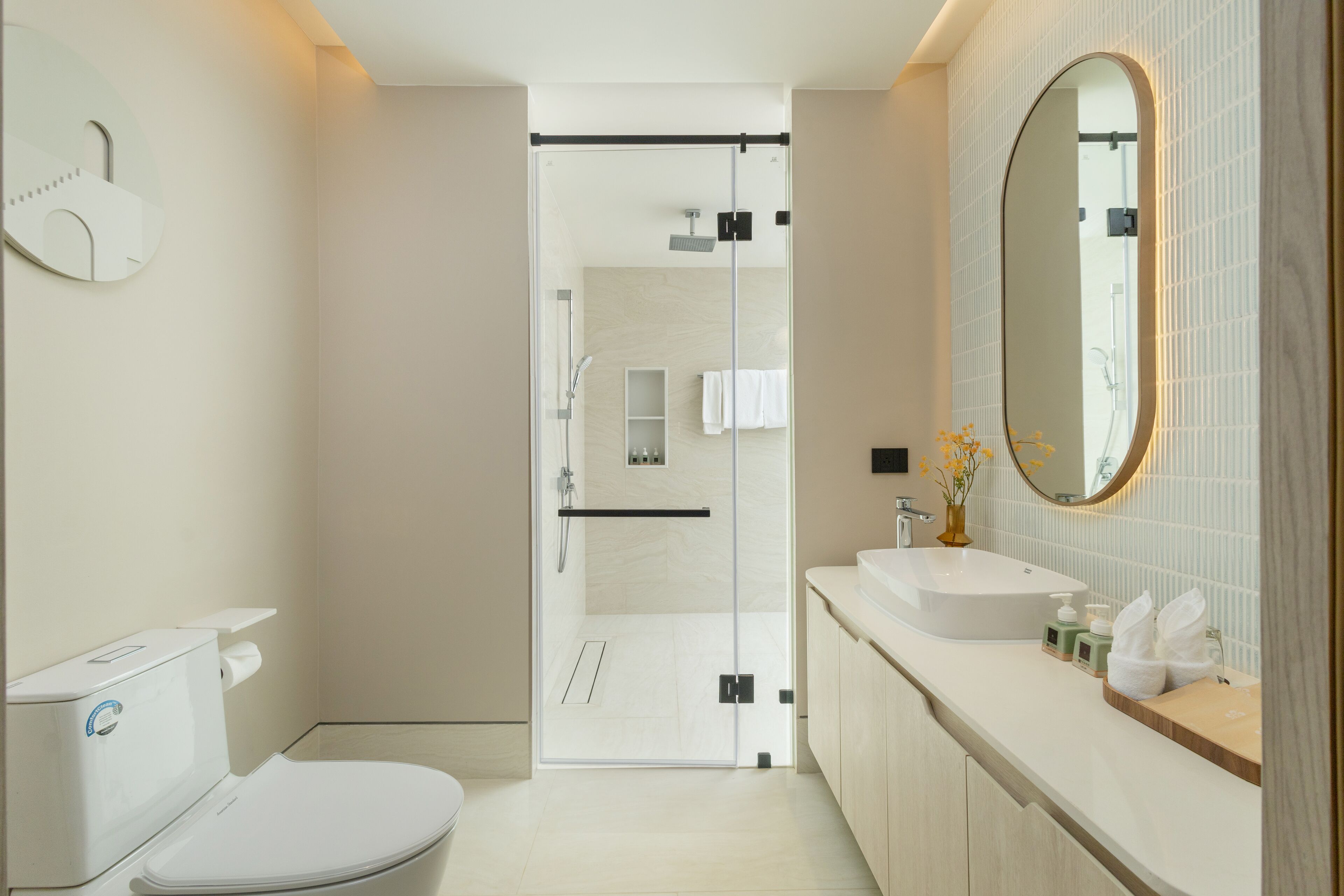 A modern bathroom with a toilet, shower, and sink.