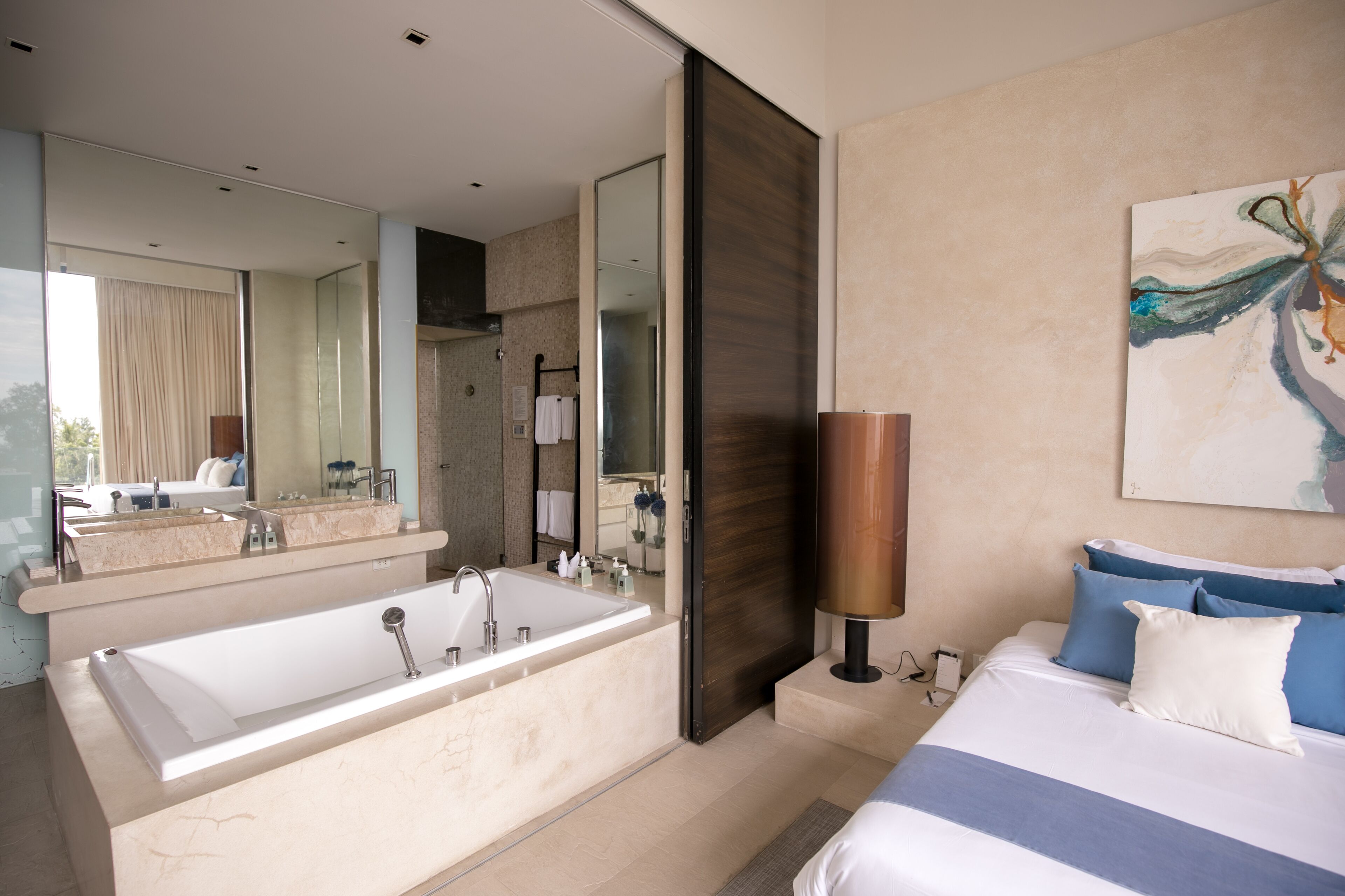 A modern bathroom with a large bathtub, a separate shower area, and a large mirror.