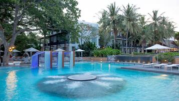 Alberca al aire libre, sombrillas en la alberca y camastros