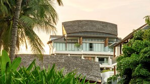 A modern building with a curved roof and multiple balconies.