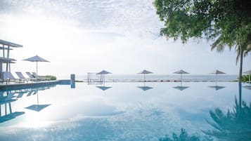 Alberca al aire libre, sombrillas en la alberca y camastros