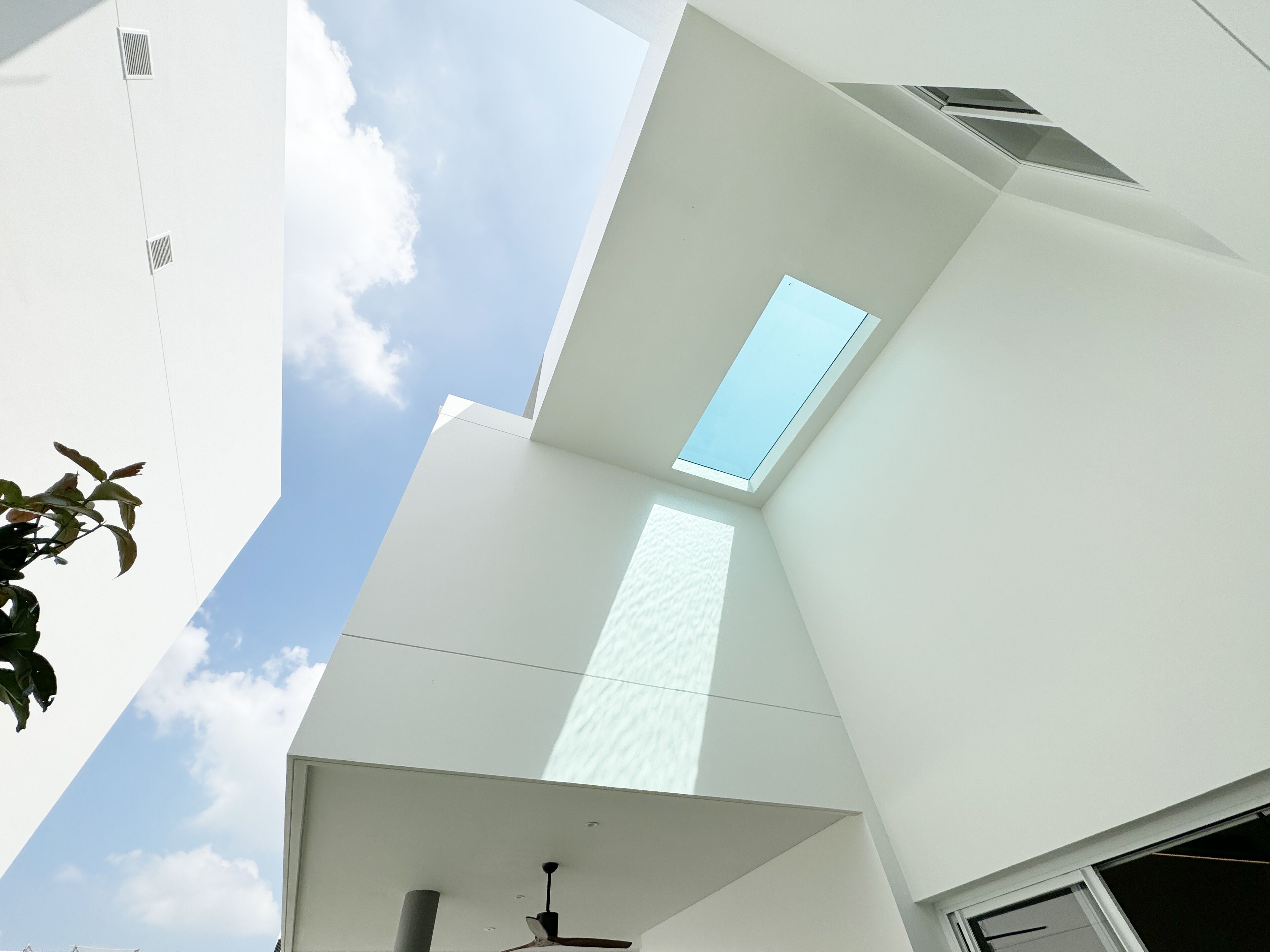 A modern building with a skylight and a visible ceiling fan.