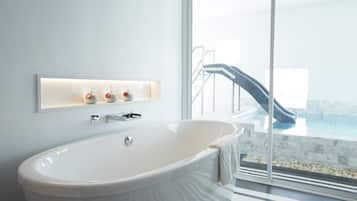 Ein modernes Badezimmer mit freistehender Badewanne, einer Duschkabine aus Glas und einem Boden mit Marmorfliesen.