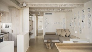 Una cocina moderna con armarios blancos, microondas integrado y una mesa de comedor de madera.