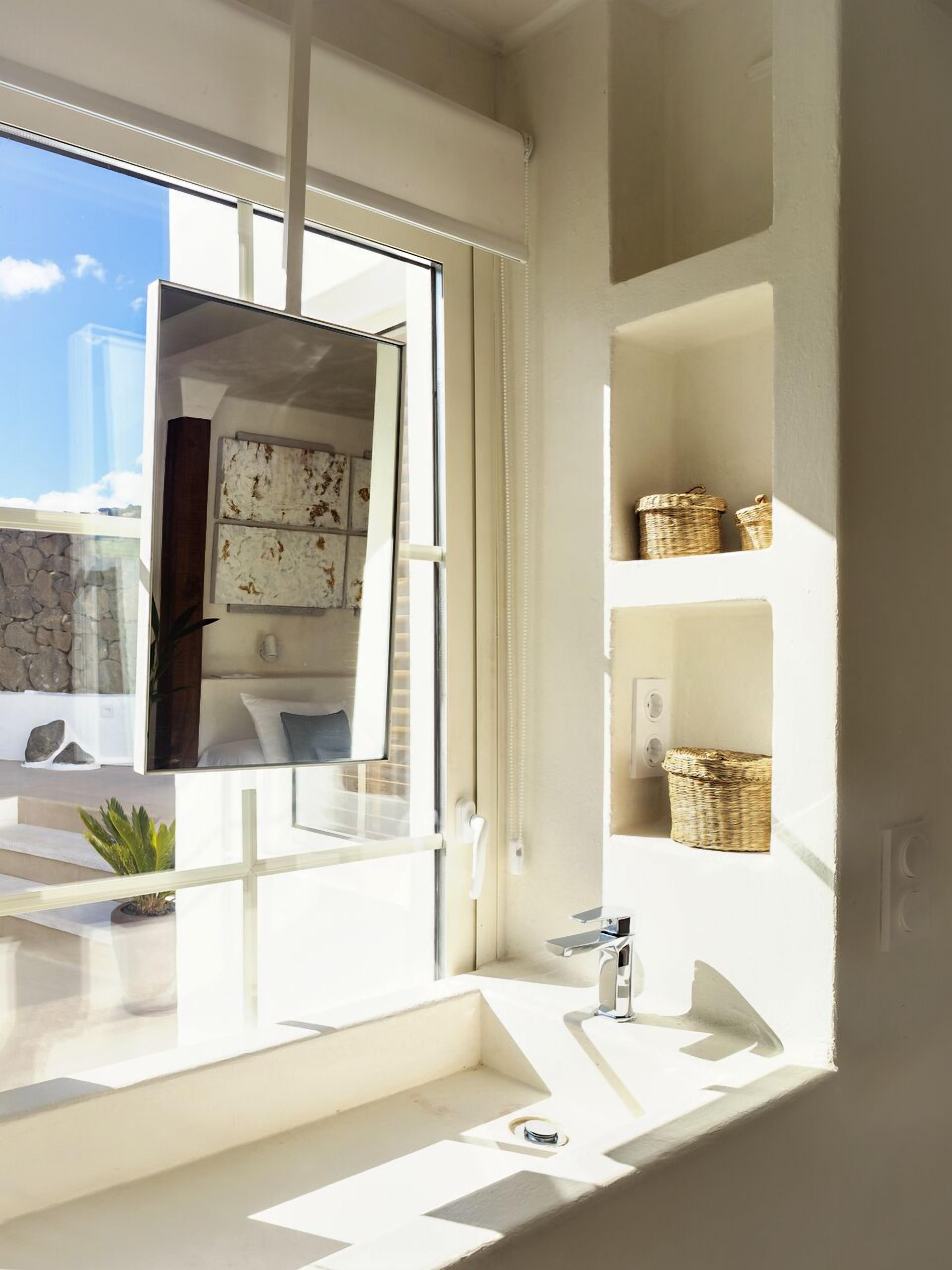 Un baño moderno con un ventanal grande, un lavabo y estantes con cestas.