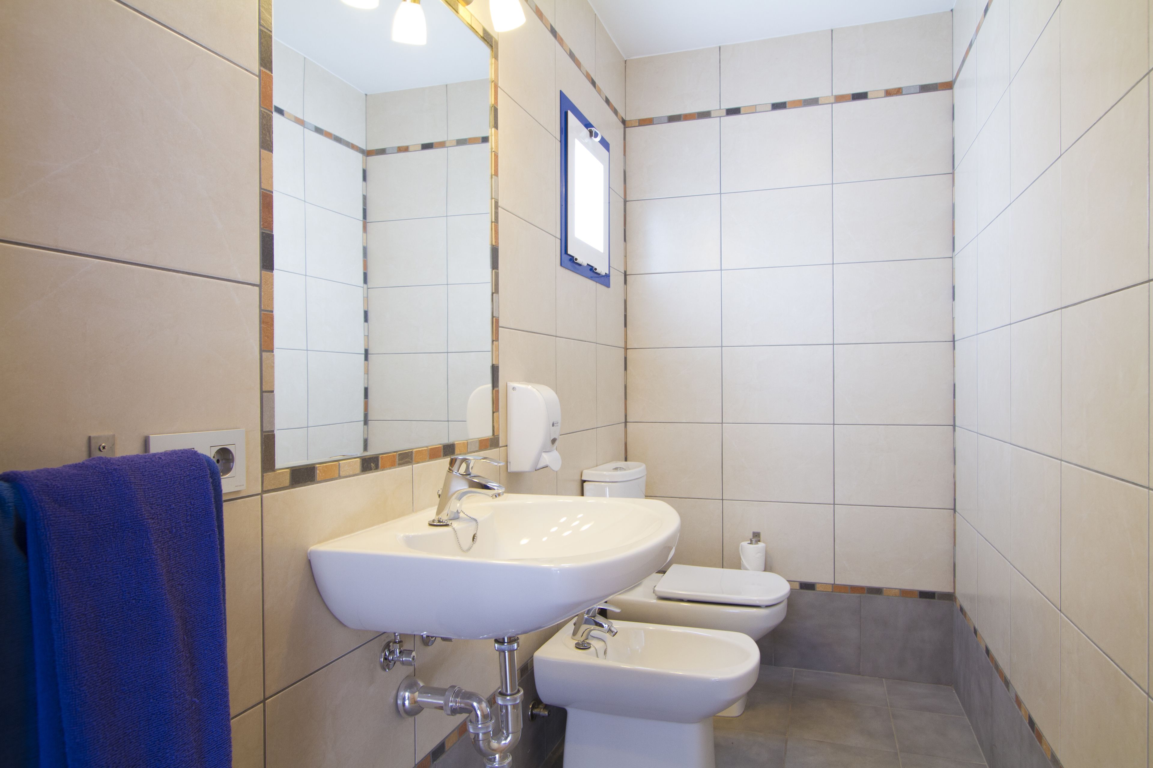 A bathroom with a sink, toilet, and bidet.