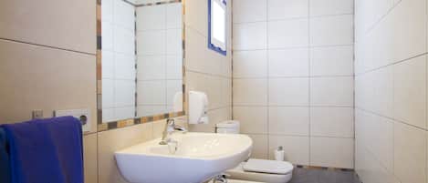 Un bagno con lavandino, WC e bidet.