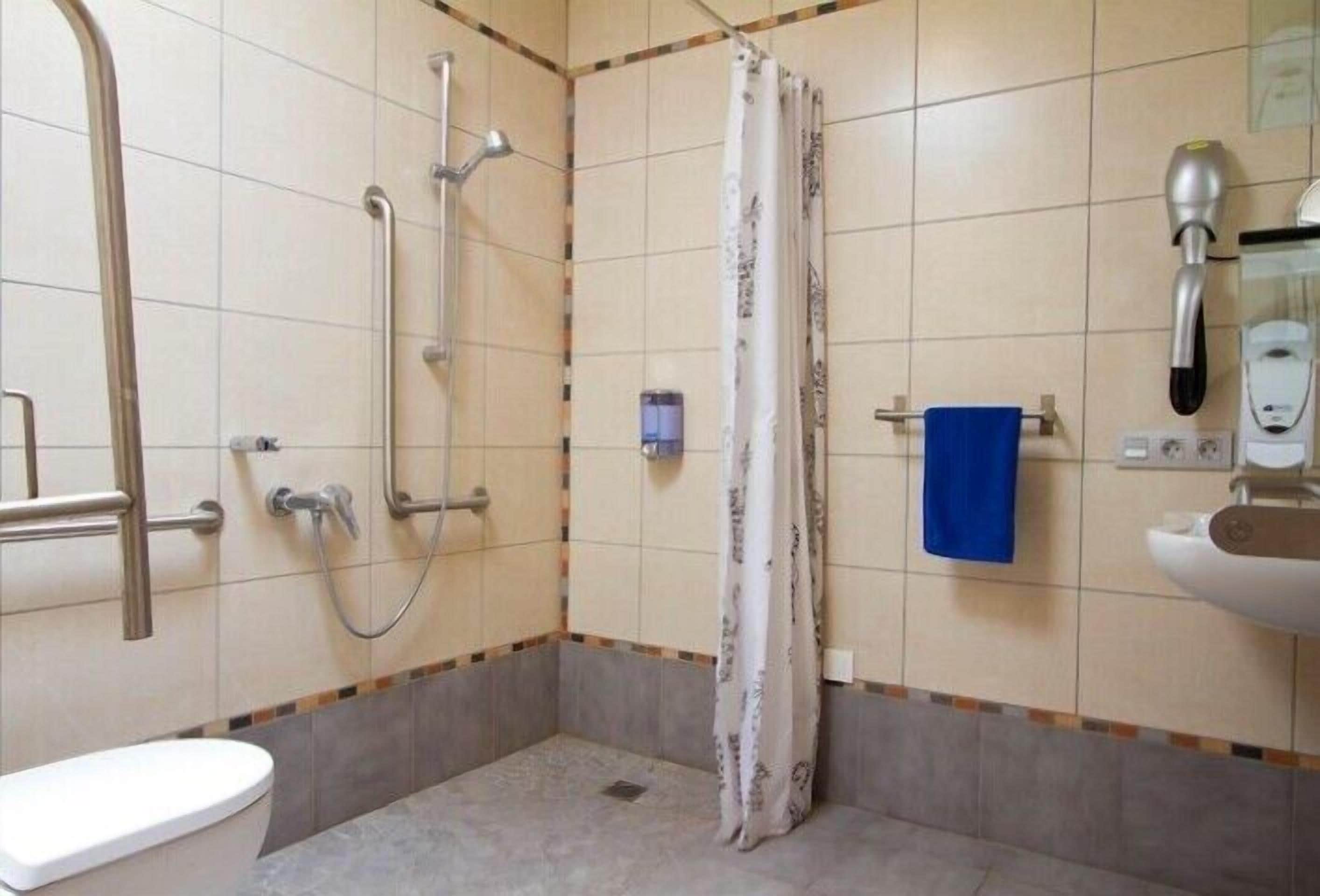 A small bathroom with a toilet, shower, and sink.