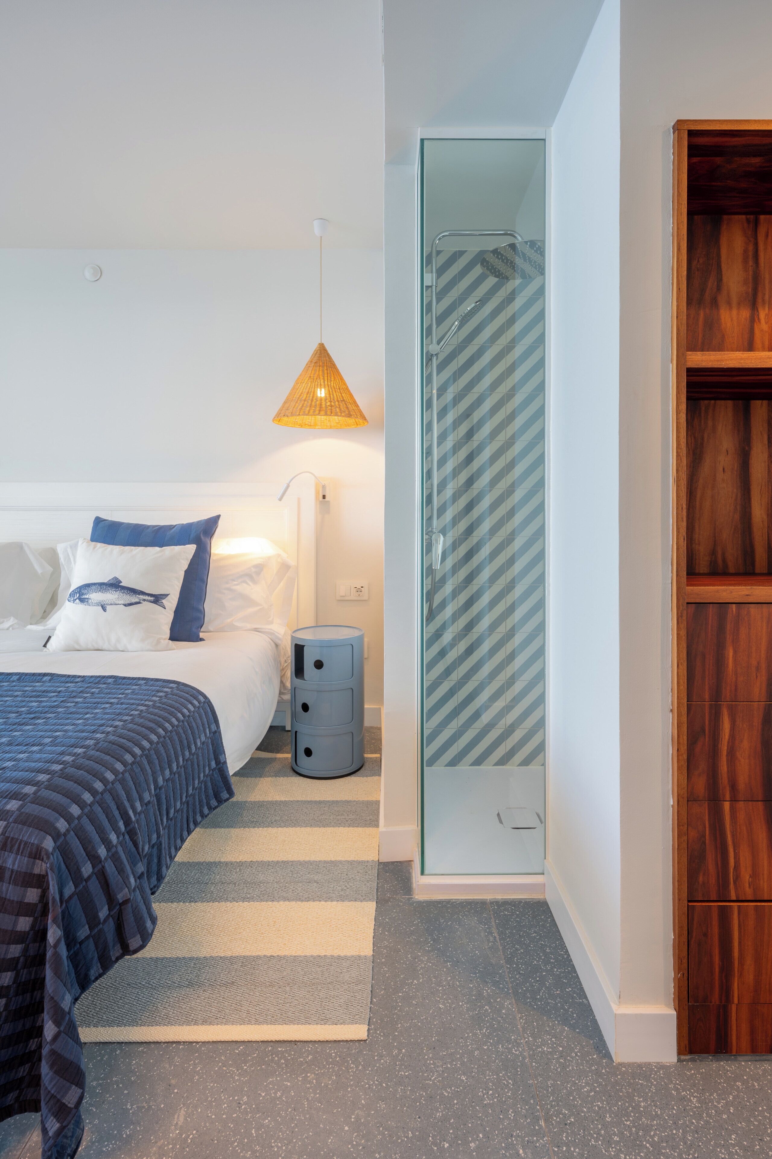 Een moderne hotelkamer met een bed, bedlamp en een douche.