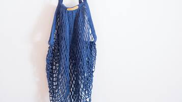 Una bolsa de malla azul colgada de un gancho en la pared.