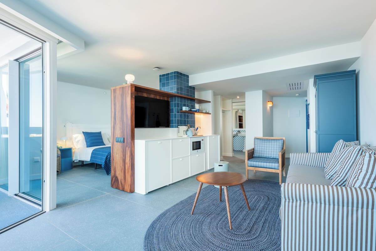 A modern apartment with a kitchen, a dining area, a living room, and a bedroom.