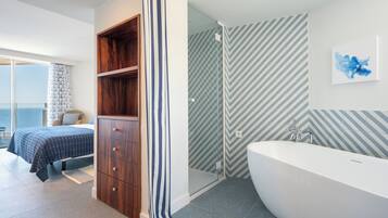Un baño moderno con una bañera independiente, un box de ducha y un mueble de madera.