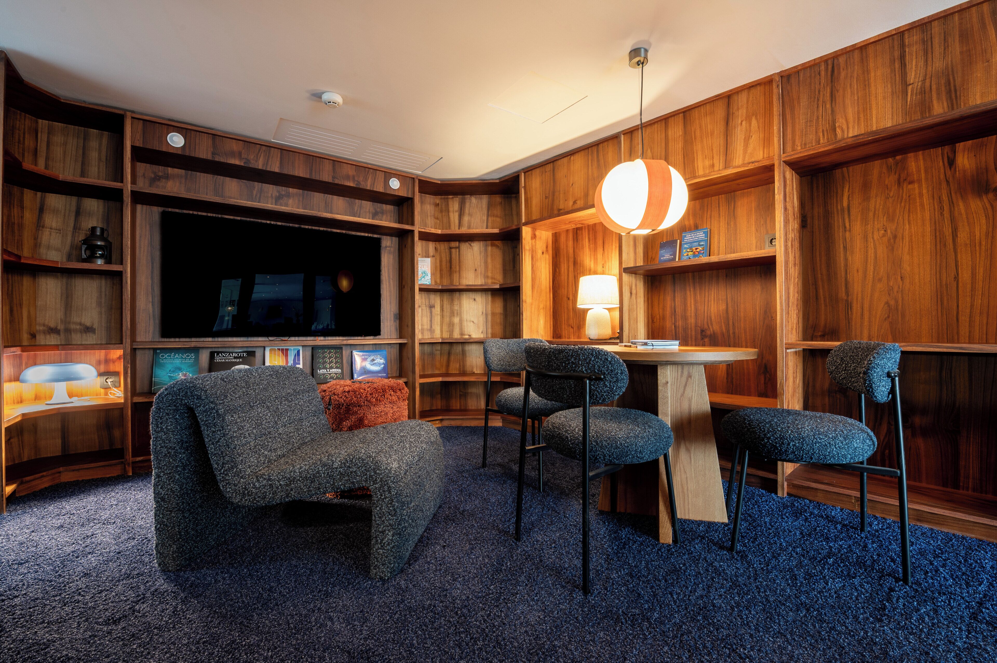 A cozy living room with a large flat-screen TV, a comfortable sofa, and a coffee table.