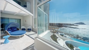 A modern balcony with a glass railing, a pool, and a view of the sea. - The Salmar - Adults Only (San Miguel de Abona)