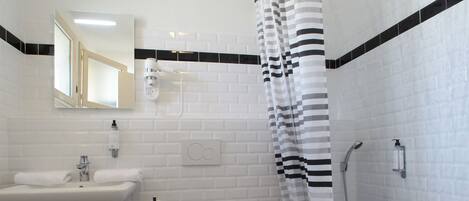 Un baño con lavamanos, inodoro y ducha.