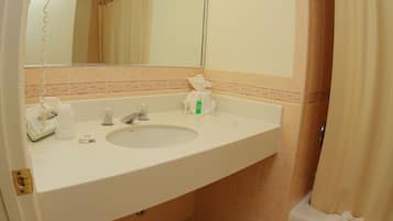 Une salle de bain avec un lavabo, un miroir et un rideau de douche.
