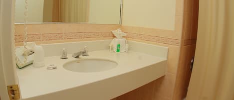 A bathroom with a sink, mirror, and shower curtain.