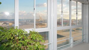 A room with large windows offering a view of a cityscape and a Ferris wheel. - Bolero Resort (Wildwood)