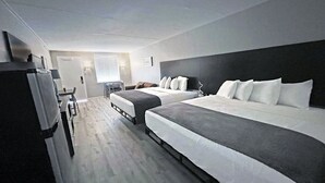 A hotel room with two beds, a desk, and a chair. - Bolero Resort (Wildwood)