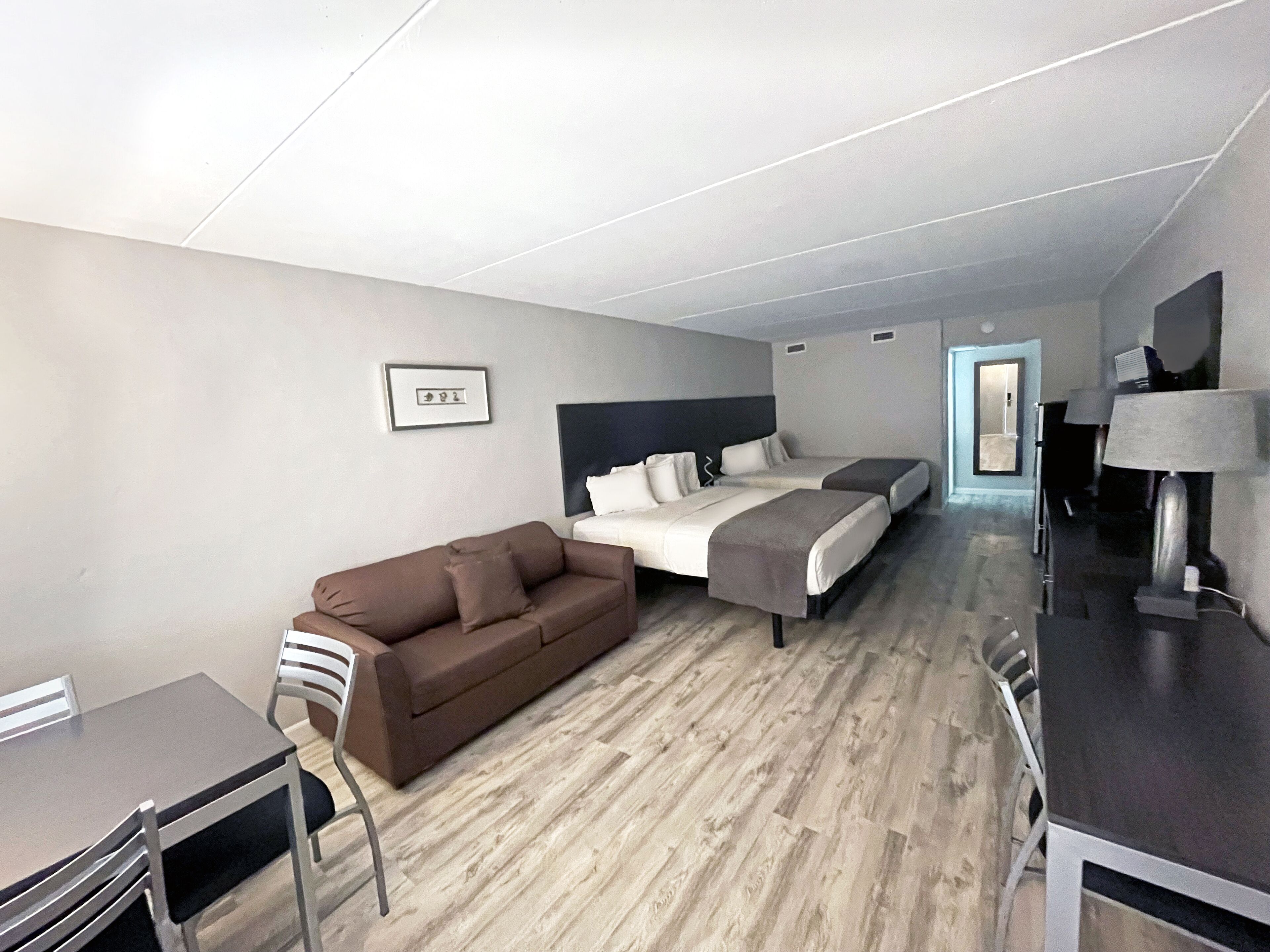 Una habitación de hotel moderna con una cama grande, un sofá, un escritorio y una silla.