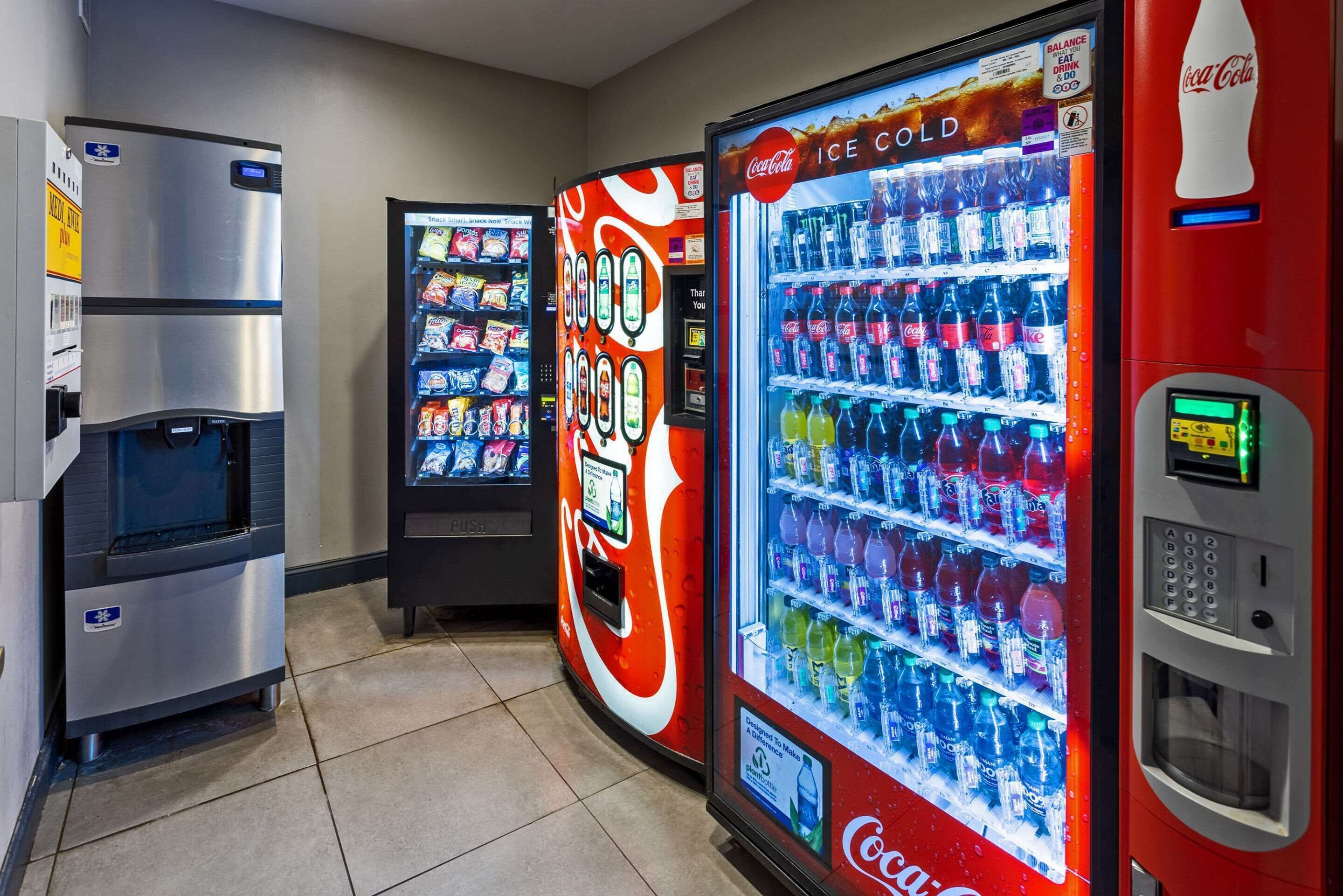 Tres máquinas expendedoras de bebidas, una con el logo de Coca-Cola y otra con un letrero que dice 'Ice Cold'.