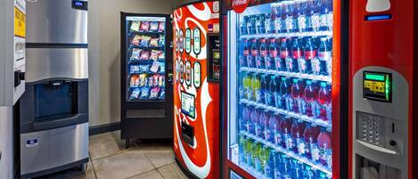Tres máquinas expendedoras de bebidas, una con el logo de Coca-Cola y otra con un letrero que dice 'Ice Cold'.