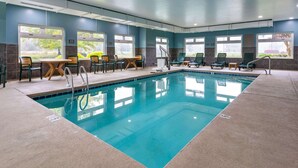 An indoor swimming pool with clear blue water, surrounded by lounge chairs and tables. - Country Inn & Suites by Radisson, Salisbury, MD (Salisbury)