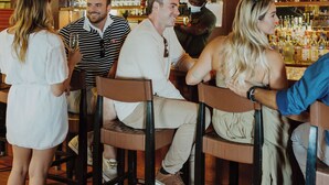 A bar with wooden floors and hanging lights, bar stools, and a variety of bottles on shelves. - Chebeague Island Inn (Chebeague Island)