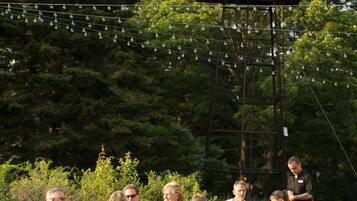 Relax in a serene outdoor space surrounded by lush greenery and string lights.