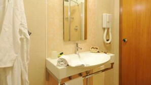 A bathroom with a sink, mirror, towel rack, and a shower area. - Hotel I Due Cigni (Montepulciano)