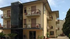 A multi-story building with balconies, a central staircase, and potted plants. - Hotel I Due Cigni (Montepulciano)