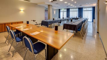 A conference room with a long wooden table, blue chairs, and a projector.