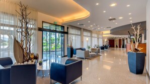 A modern hotel lobby with a curved ceiling, seating areas, and large windows offering a view of the outdoors. - Best Western Hotel Turismo (San Martino Buon Albergo)
