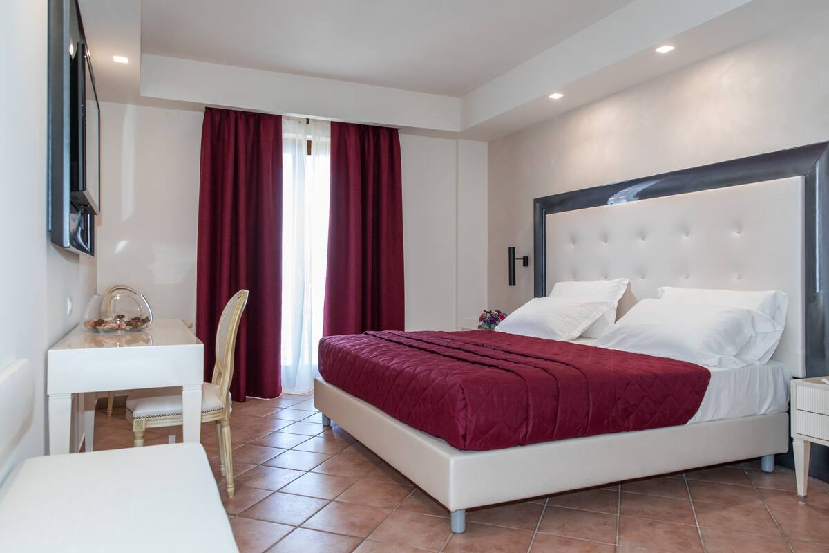 Un dormitorio con cama, escritorio y silla.