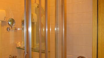 Un bagno con doccia vetrata, lavandino e specchio.