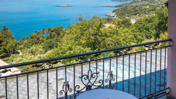 A balcony with a view of the sea, a table, and two chairs. - Hotel Martino (Maratea)