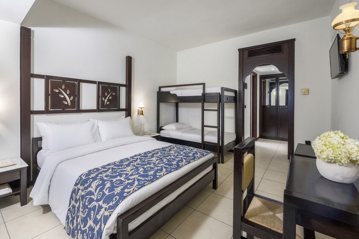 A bedroom with a large bed, a bedside table, a mirror, and a nightstand.