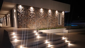 A modern building with a stone facade and illuminated steps leading to a door. - Zoes Hotel (Rhodes)