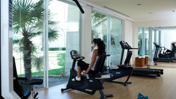 Ett gym med konditionsmaskiner, ett löpband och en motionscykel.