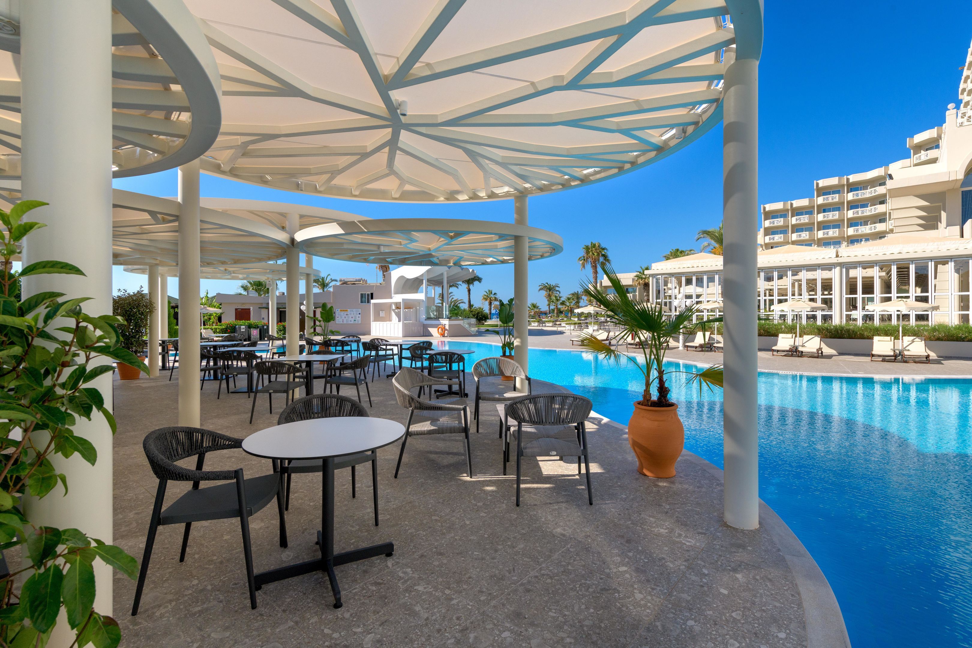 A poolside area with outdoor seating and a large pool.