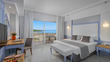 Una habitación de hotel moderna con una cama grande, un escritorio y un balcón con vistas al mar.