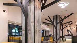A modern interior with a central seating area, a reception desk, and a view of the outside through a glass partition. - City Center Hotel (Rhodes)