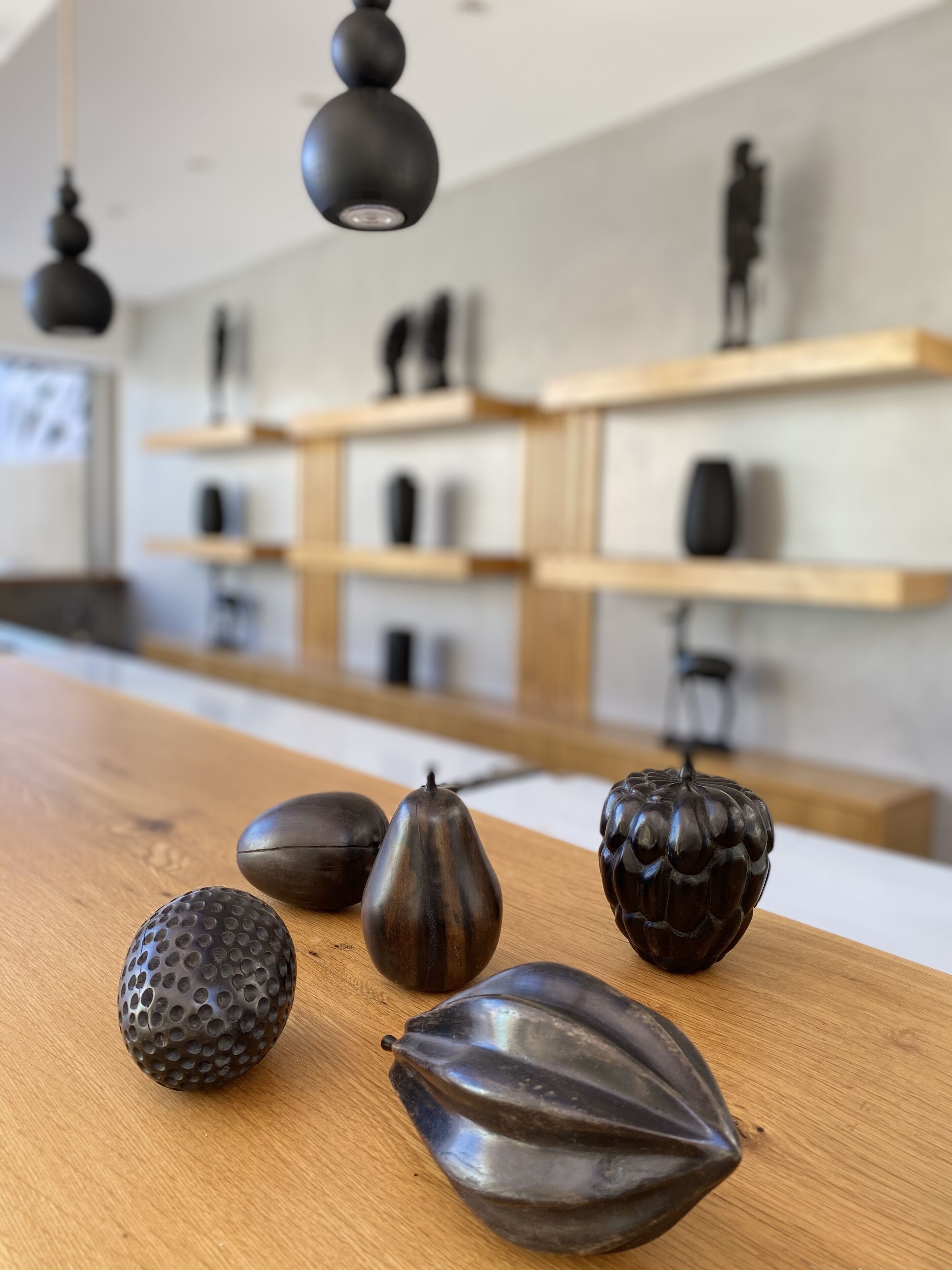 A wooden table with decorative objects and a modern kitchen in the background.