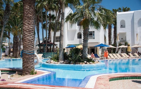 Una piscina al aire libre de temporada, sombrillas