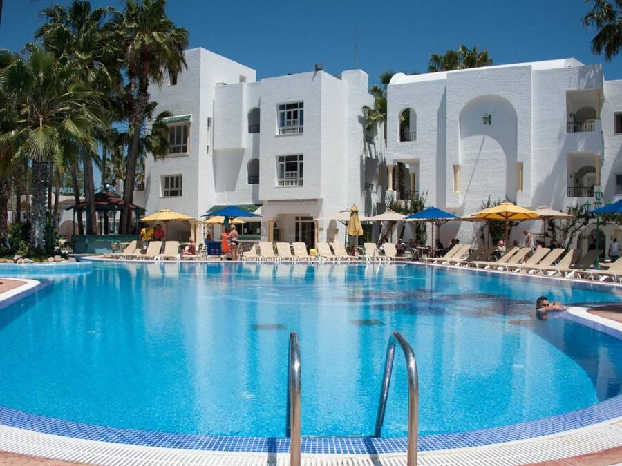 Una piscina al aire libre de temporada, sombrillas